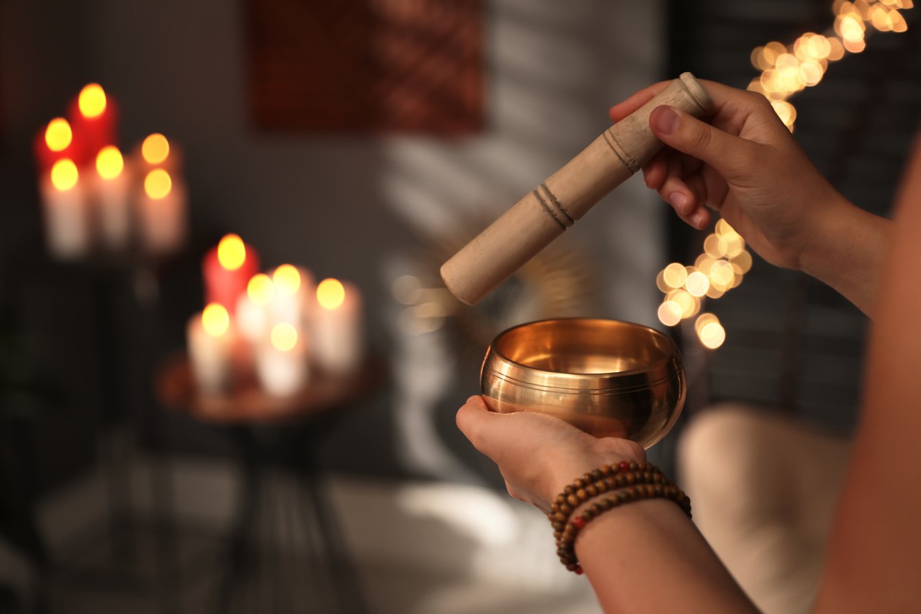 Healer Using Singing Bowl in Dark Room, Closeup